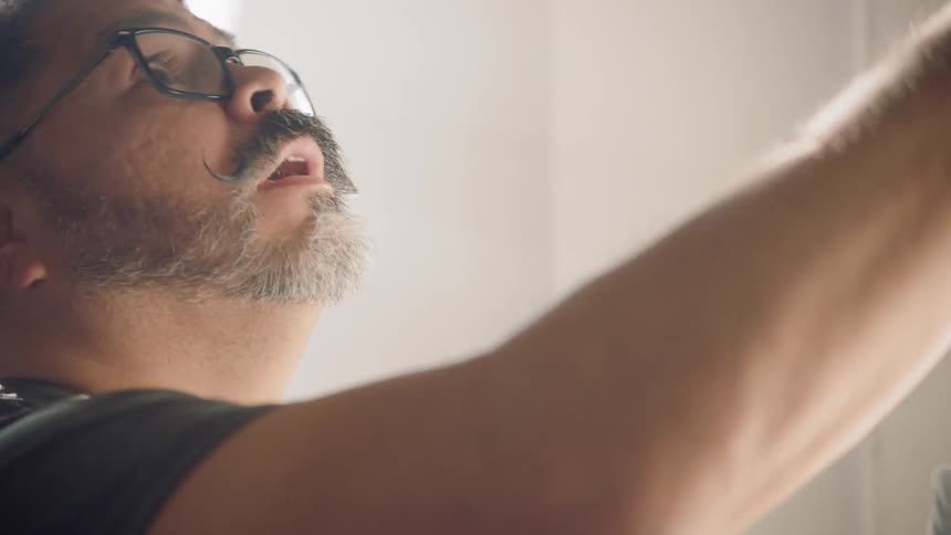Man studies wall in room consulting document