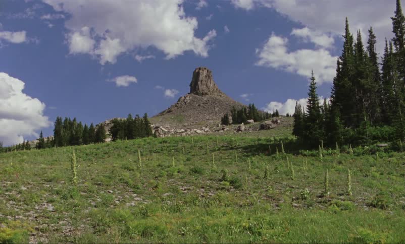 A small rock hill sits in a field