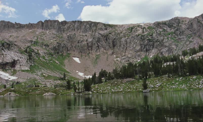 Lake at center of valley reflects mountains and forest