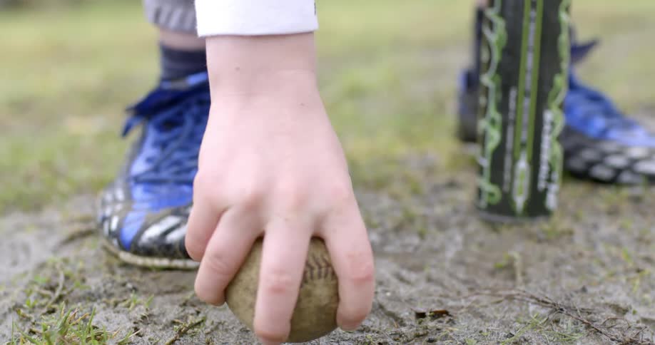 A boy picking up a baseball