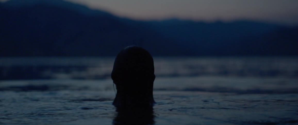 A woman comes up from swimming in the sea