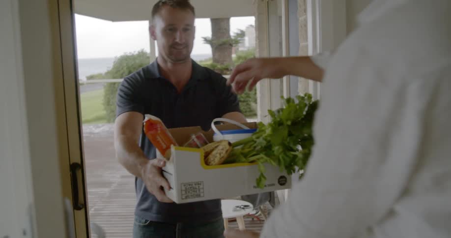 A man delivers produce to a house