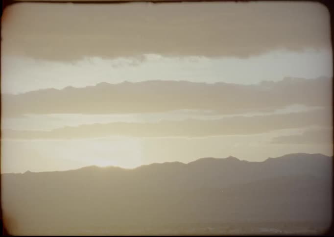 The sun is rising behind the mountains