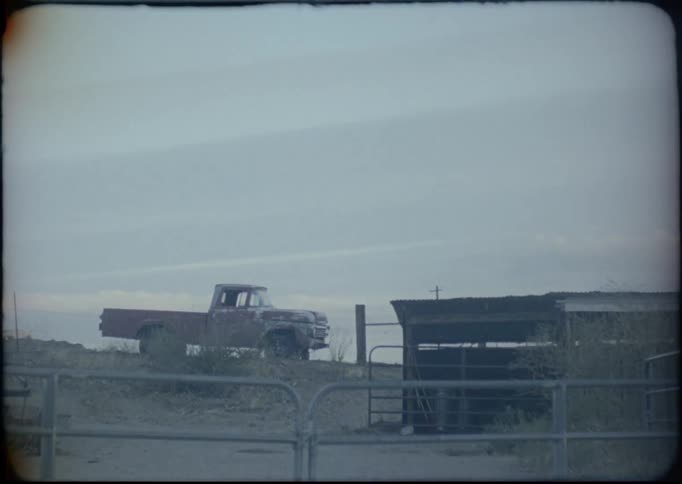 An old truck sits in a farm yard