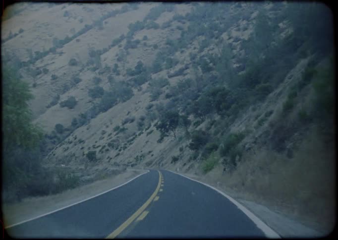 A vehicle traveling along a narrow mountain road