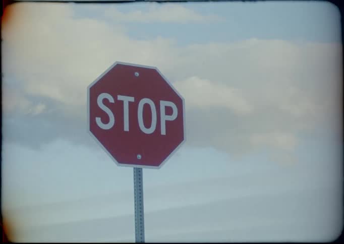 A stop sign with the sky and clouds in the background