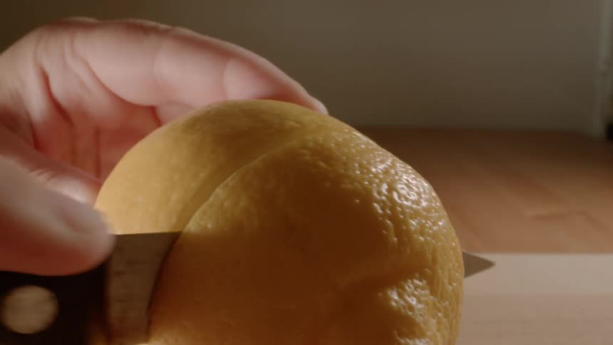 A person cuts into a lemon