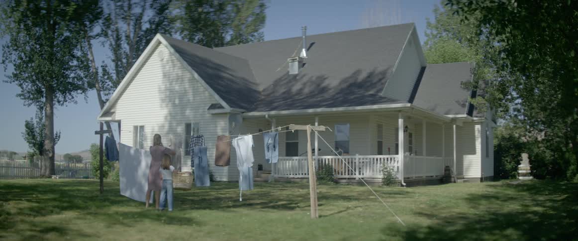 Mother and daughter hanging laundry on a clothesline in the country