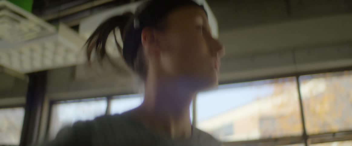 A young woman runs on a treadmill