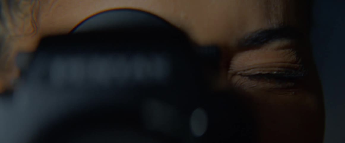 A young black woman raising a camera to her face