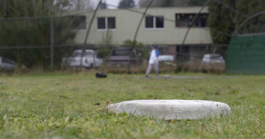 A boy throws a baseball in the air and tries to catch it