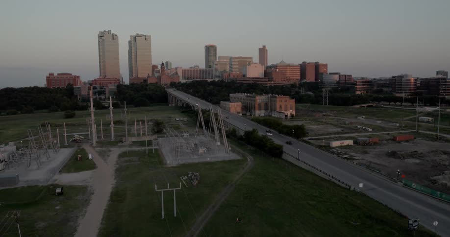 Cars drive on a highway headed into a city