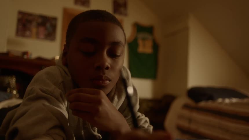 Black boy study in his room at night