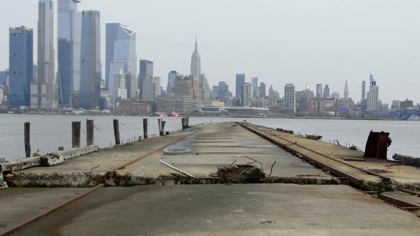 The pier leads to the water before the city