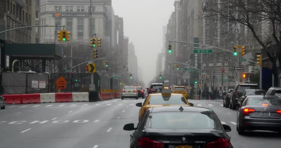 Vehicle traffic passes through a busy city intersection