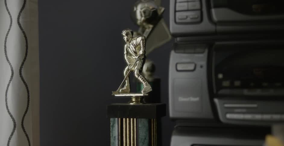 A hockey trophy sits on a table next to a stereo