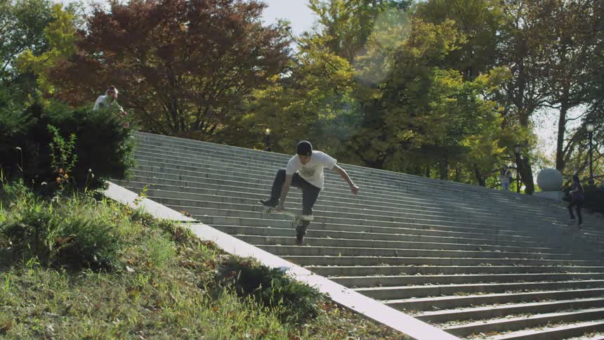 A man skateboards on city steps