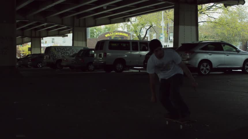 A boy in a white shirt does a skateboard trick