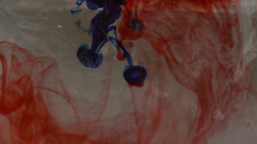 Colored dyes mix together in a clear liquid
