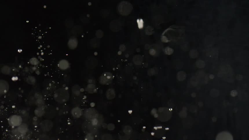 A white tablet being dropped into a clear glass of liquid