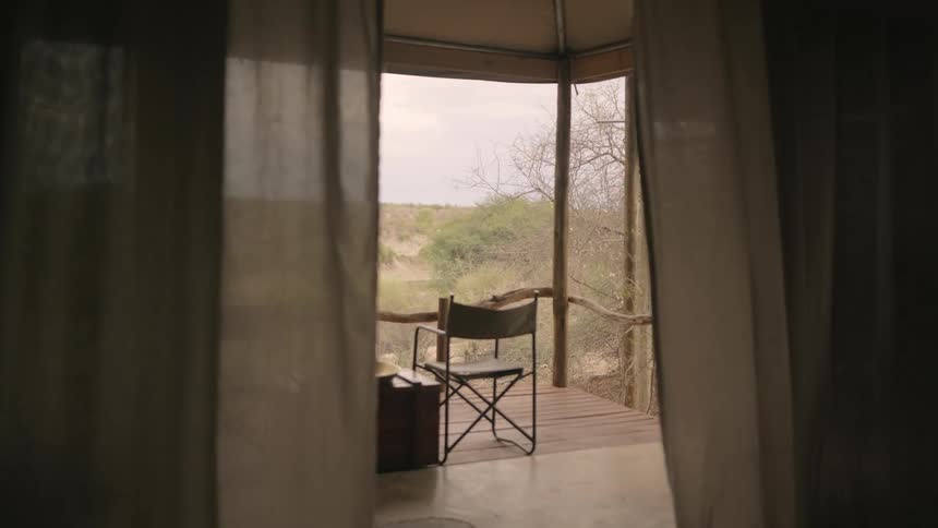 An interior room expands to a large open porch in a remote area