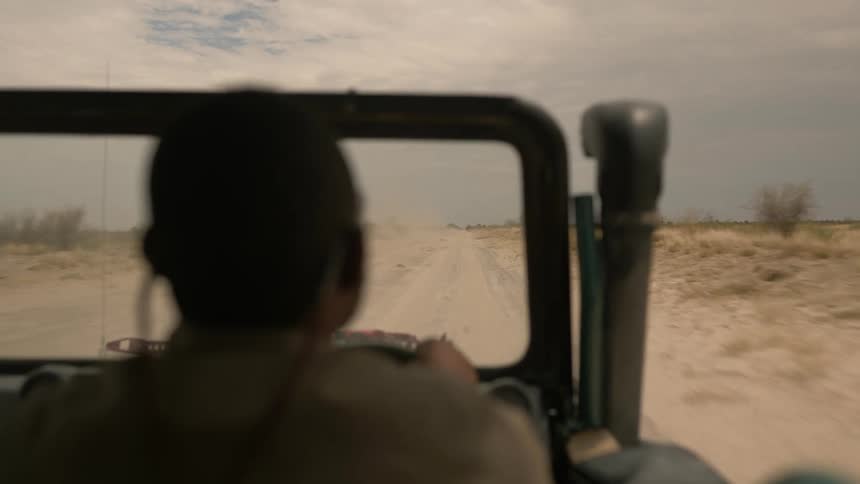 A man is racing a jeep on a desert path