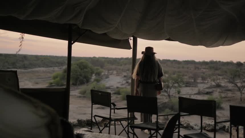 A woman walking in a camp with trees in the foreground
