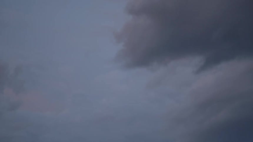 Dark clouds move across the sky at dusk