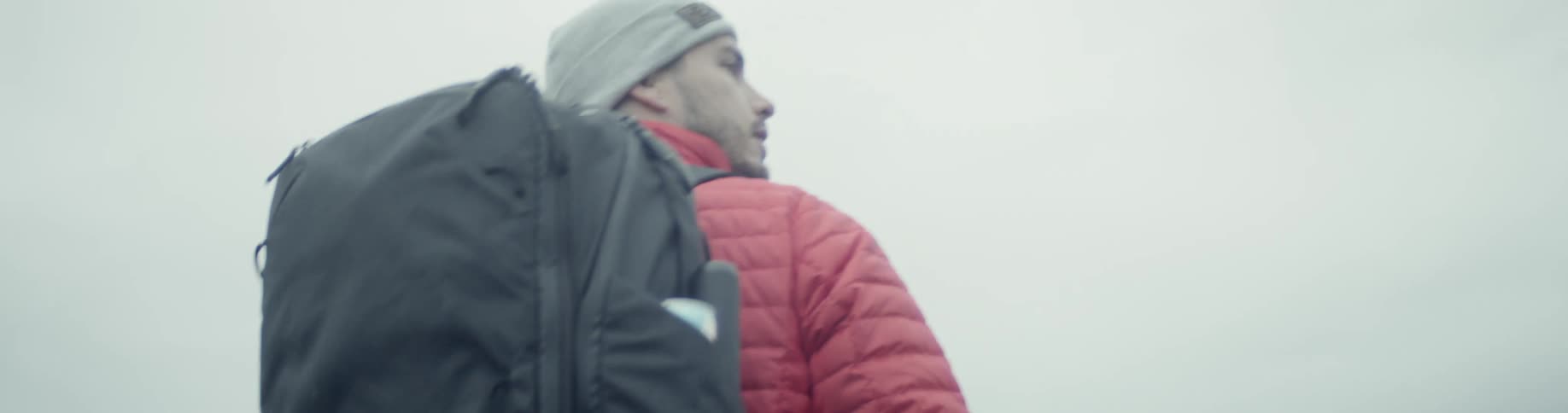 A man is hiking carrying a camera