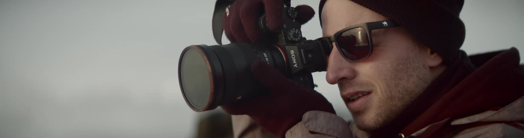 A man looks through a large camera