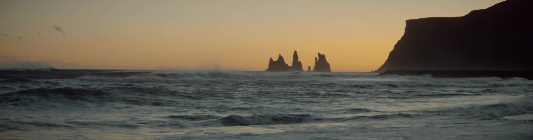 Ocean waves flow towards a beach at sunset