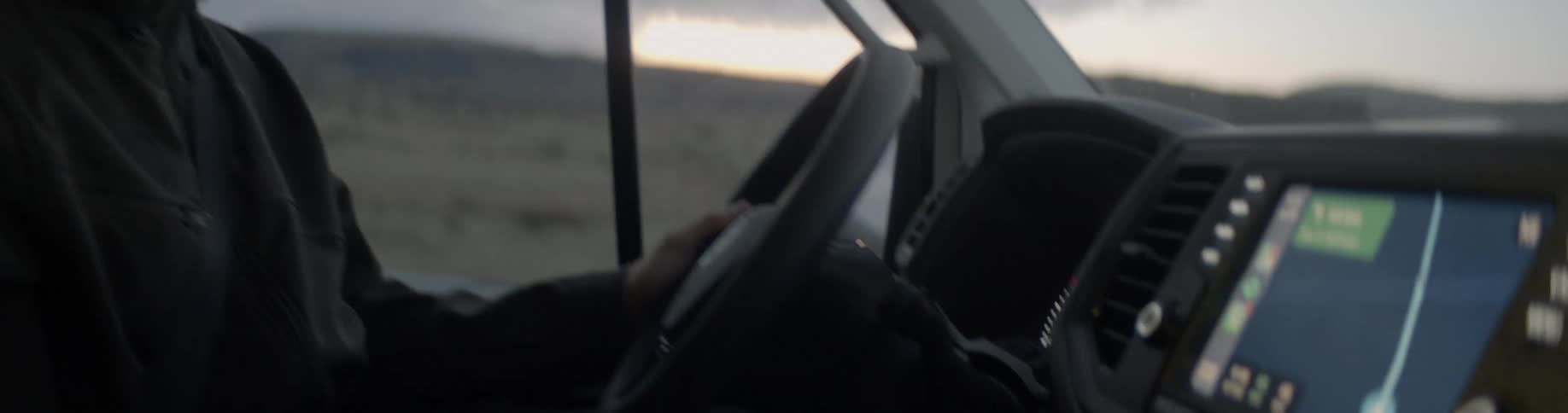 A man chats while driving through a field