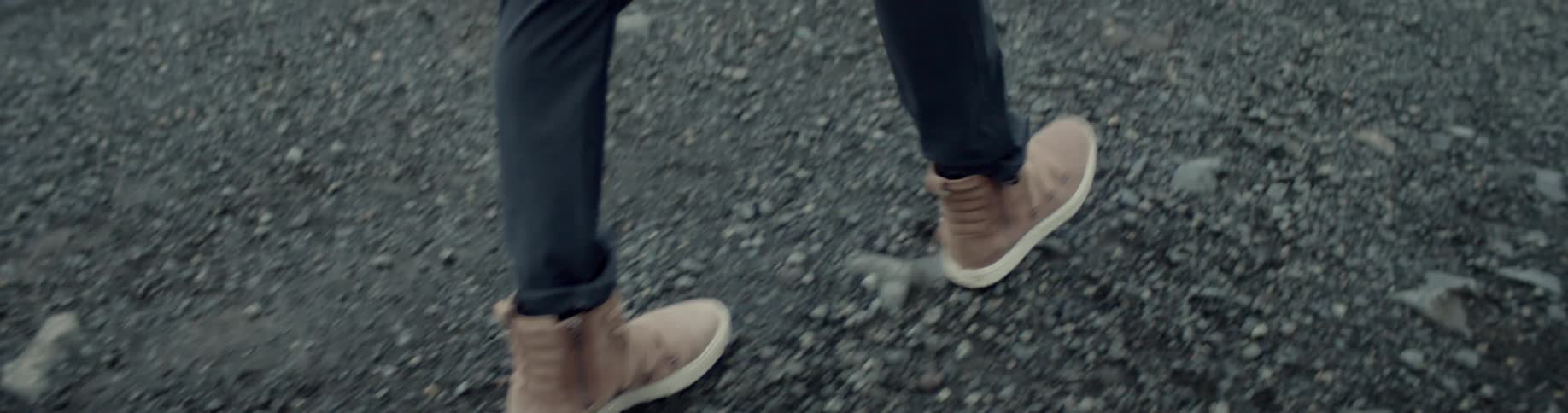Person walks along gravel surface in hiking boots