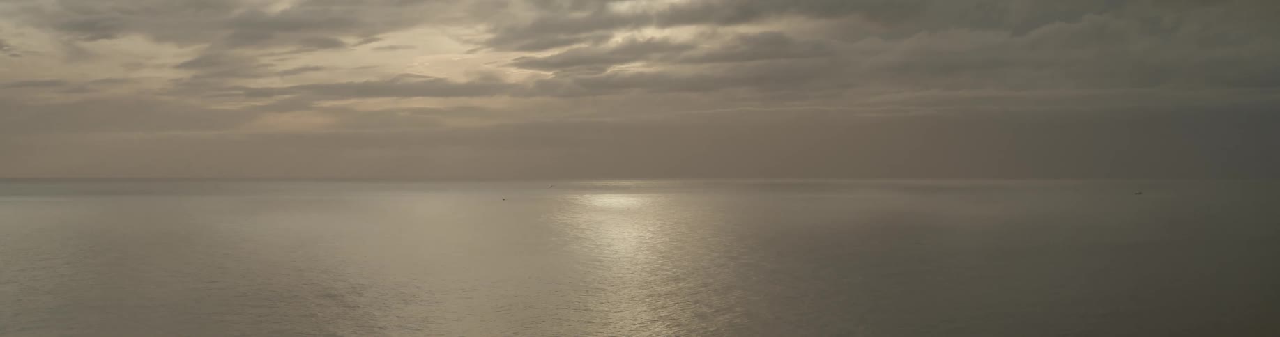 A panoramic view of the sun rising over the ocean