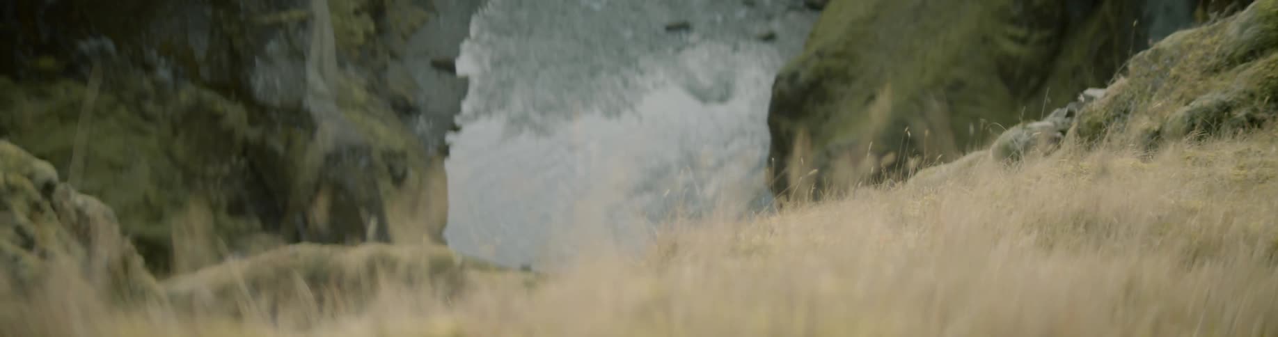 Grass on a cliff looking down at a body of water