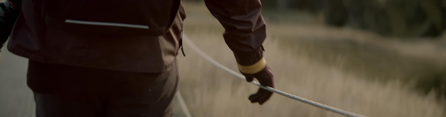 Man walksalong path holding guide rope