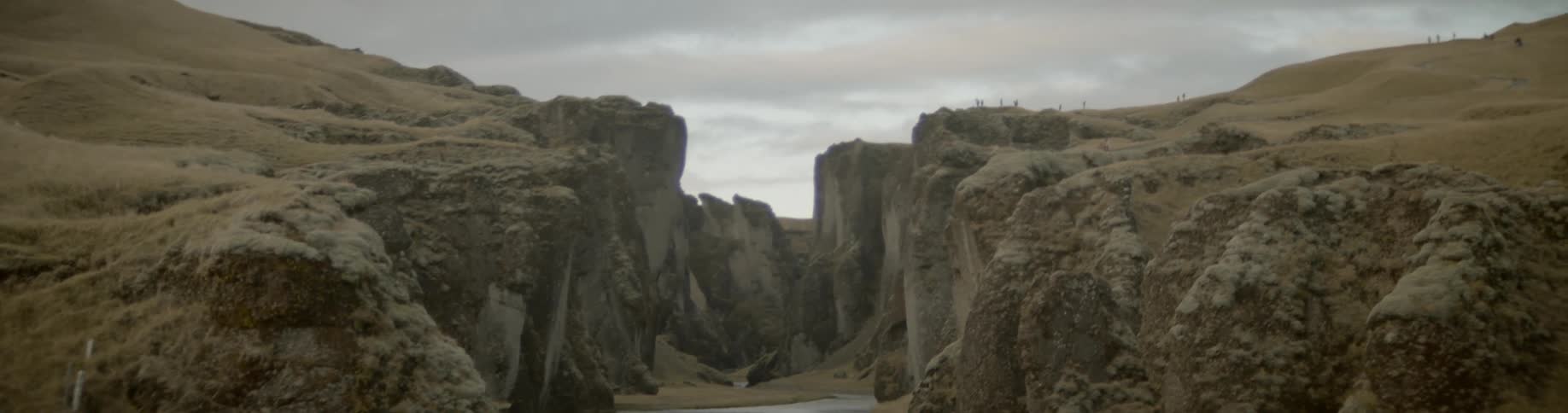 A winding river through a canyon on a cloudy day