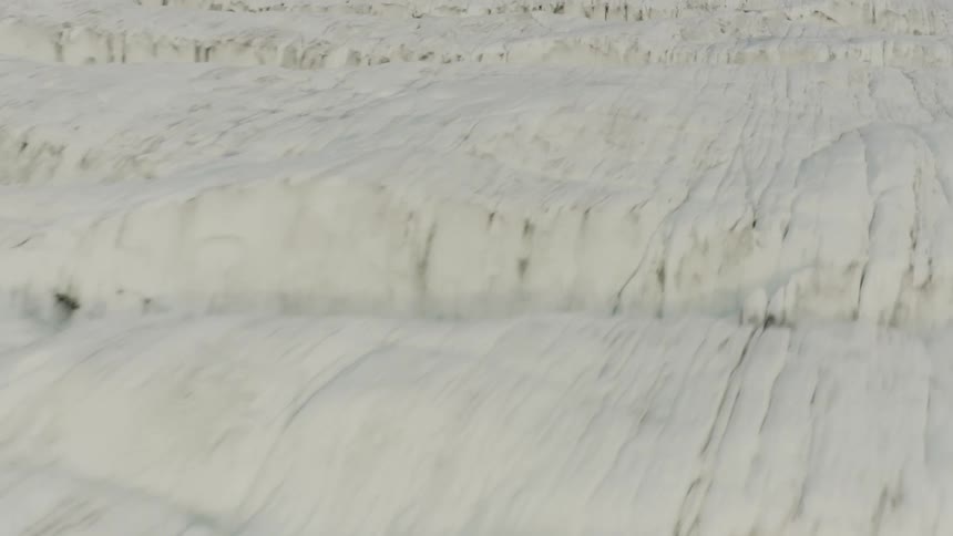 Ice freezes over snow covered ground creating ripples