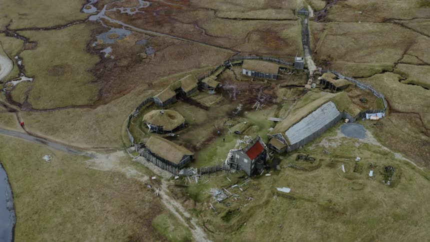 Aerial view of a small european walled village in grassland near lake