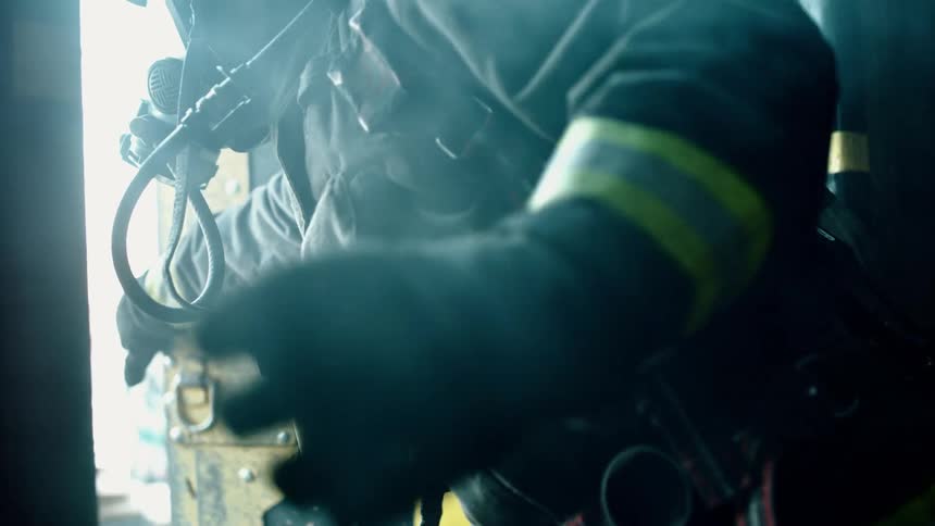 A firefighter reaches for a door