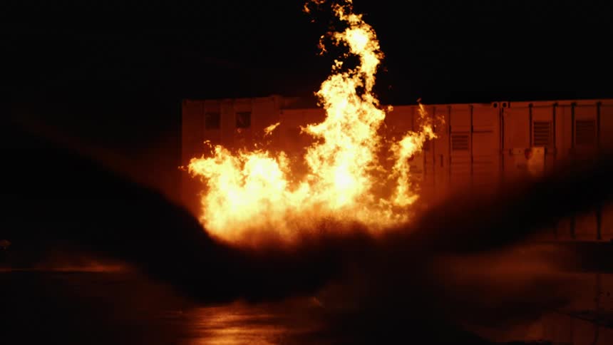 Water is sprayed on a large fire outside