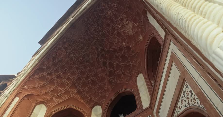 The ornates ceiling of a half dome entrance with arched windows and mosaic tile