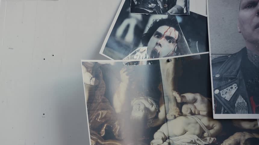 Pictures of people covered in blood and suffering hang on a wall