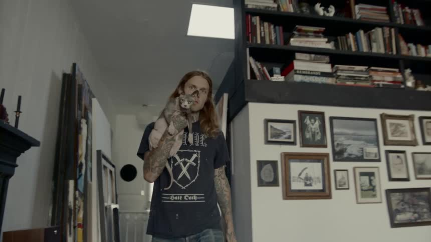 Man walks into living room holding cat