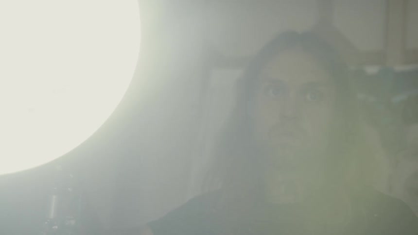 Long haired man turns the spotlight in the workshop