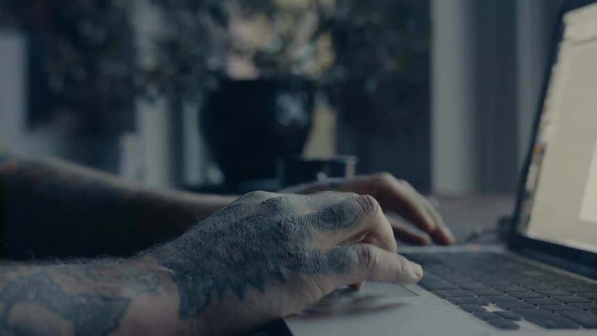 Man sitting at the desk uses laptop in the room