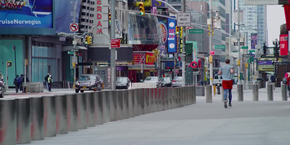 A man jogs down a city sidewalk