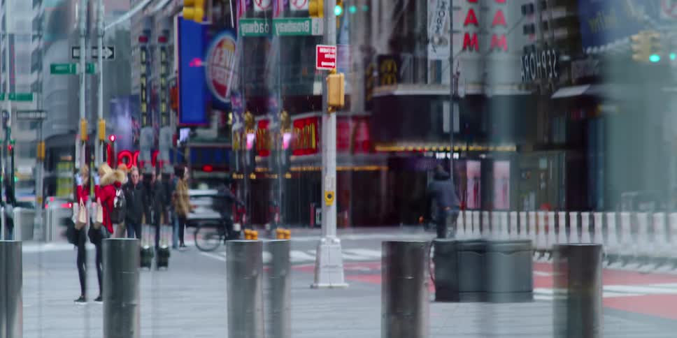 A city sidewalk and street can be seen through a refractive glass window