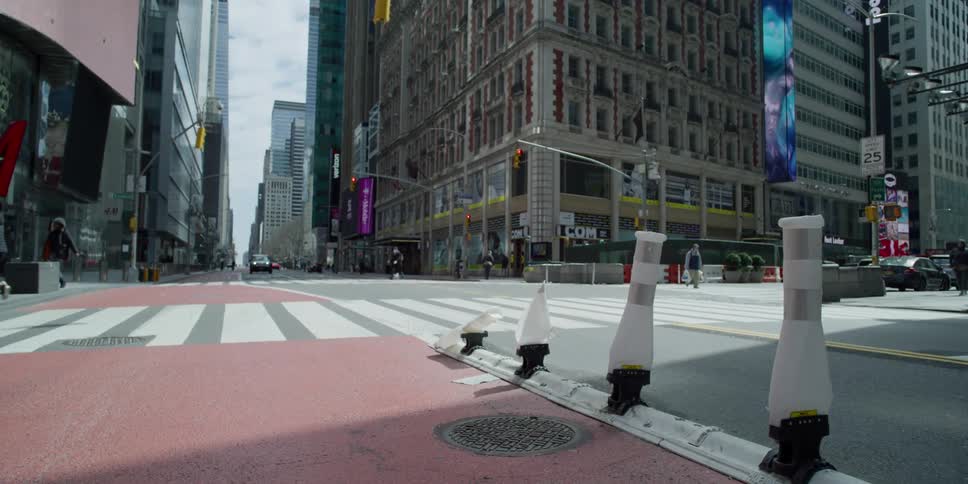A city street with people buildings and vehicles