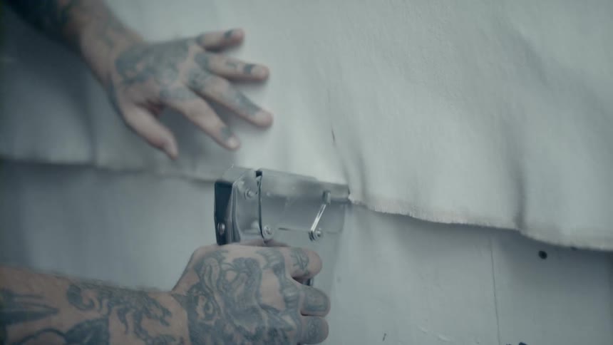 A man staples fabric together